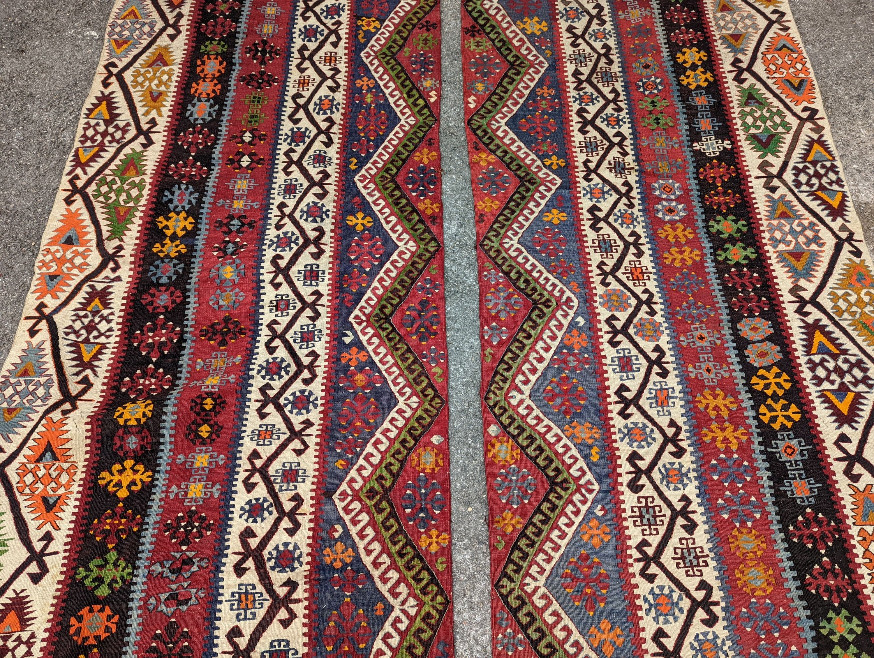 A Kilim polychrome flatweave carpet, cut centrally to create a pair of runners, each 440 x 97cm